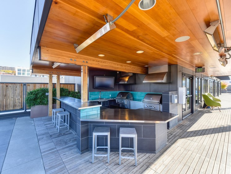 Rooftop BBQ Area with Grills, Mounted Flat Screen Television, Green Chairs, Bar Stool Seating